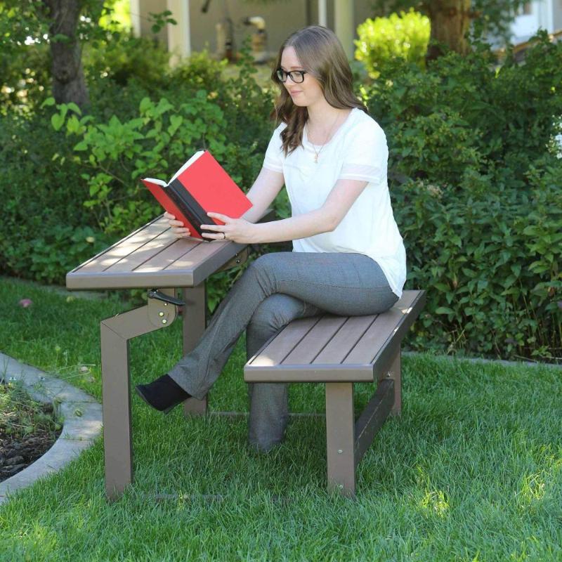 Banco de jardín con modelo sentada en jardín leyendo un libro en posición de mesa Lifetime