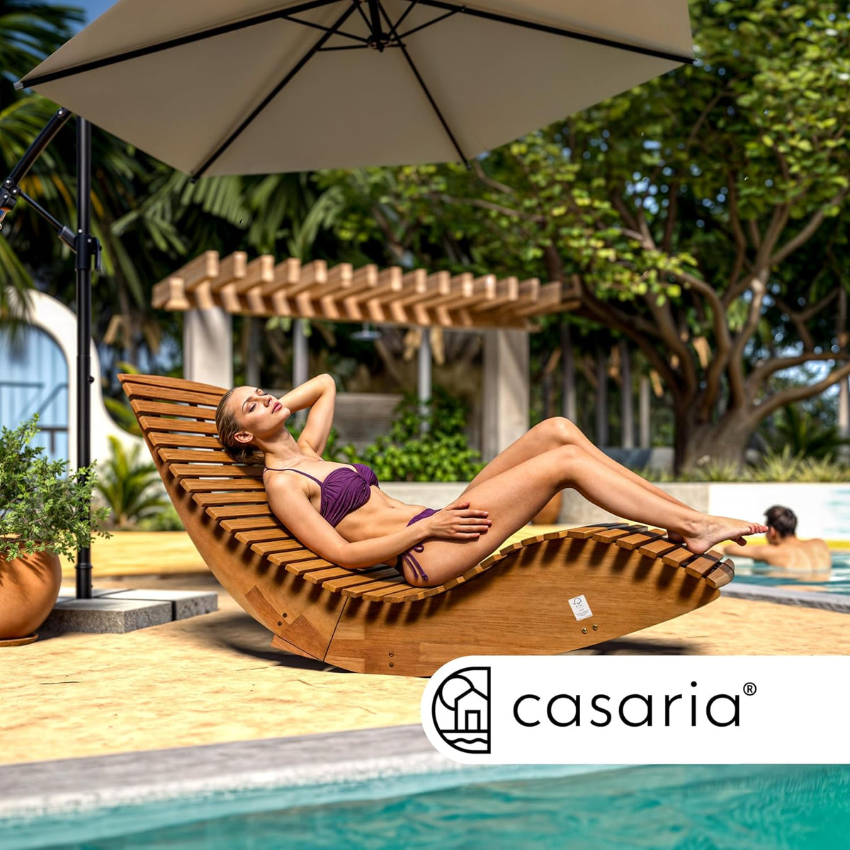 Vista de modelo sentada en la tumbona mecedora Casaria de madera en bonita terraza con piscina