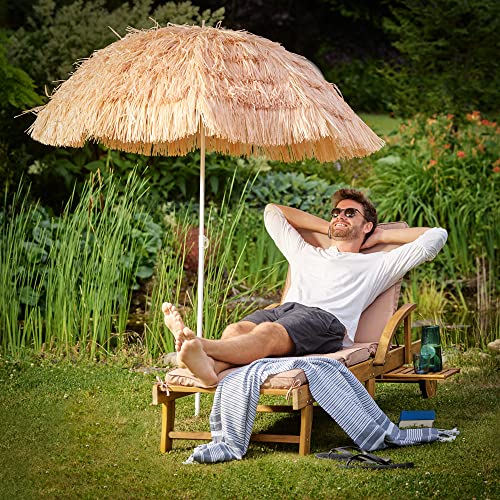 Tomando el sol en el jardín con la Sombrilla de Playa Hawaiana Ø 160cm Inclinable de Rafia o paja Color Natural. Kingsleeve