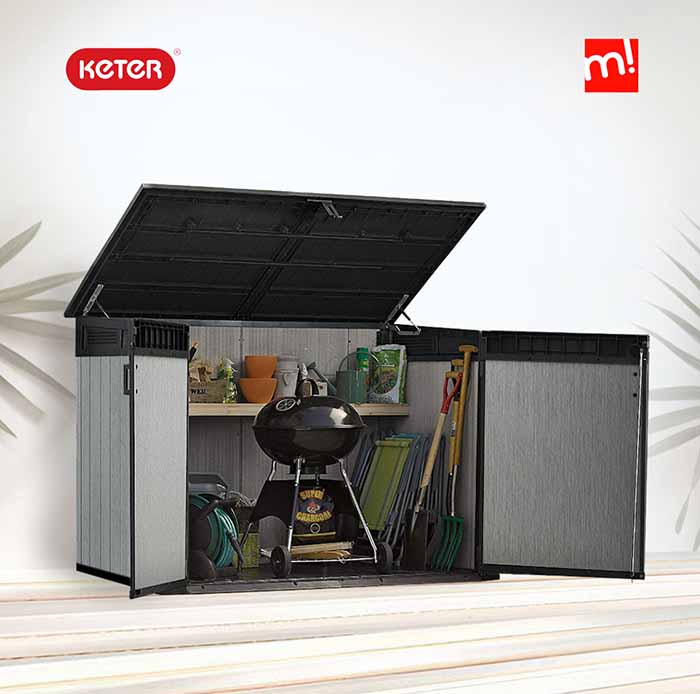 Cobertizo de jardín exterior Duotech Grande Store de Keter con tapa y puertas abiertas con barbacoa y útiles de jardinería en su interior sobre fondo de patio con logo de Keter y Maxjardín