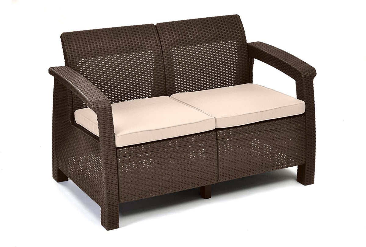 Conjunto de jardín de 4 plazas: 1 asiento doble y 2 sillones individuales con cojines y 1 mesa baja en ratán marrón. Detalle de sofá doble marrón con cojines crema.Corfu. Keter