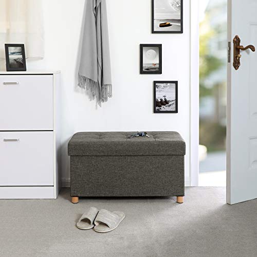 Vista en ambiente de entrada de vivienda con el Taburete con Almacenamiento Plegable Rectangular Tapizado con acolchado de Esponja con Patas de Madera Maciza y Tapa Gris Oscuro LSF16GYZ. SONGMICS